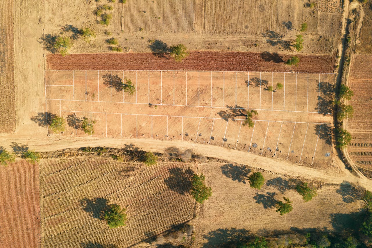 gallery-6 Drone shot of a rural farm landscape with fields and trees in summer.