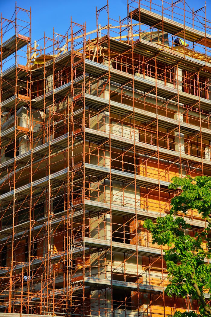 services-02 A multi-story building under construction with scaffolding on a sunny day.