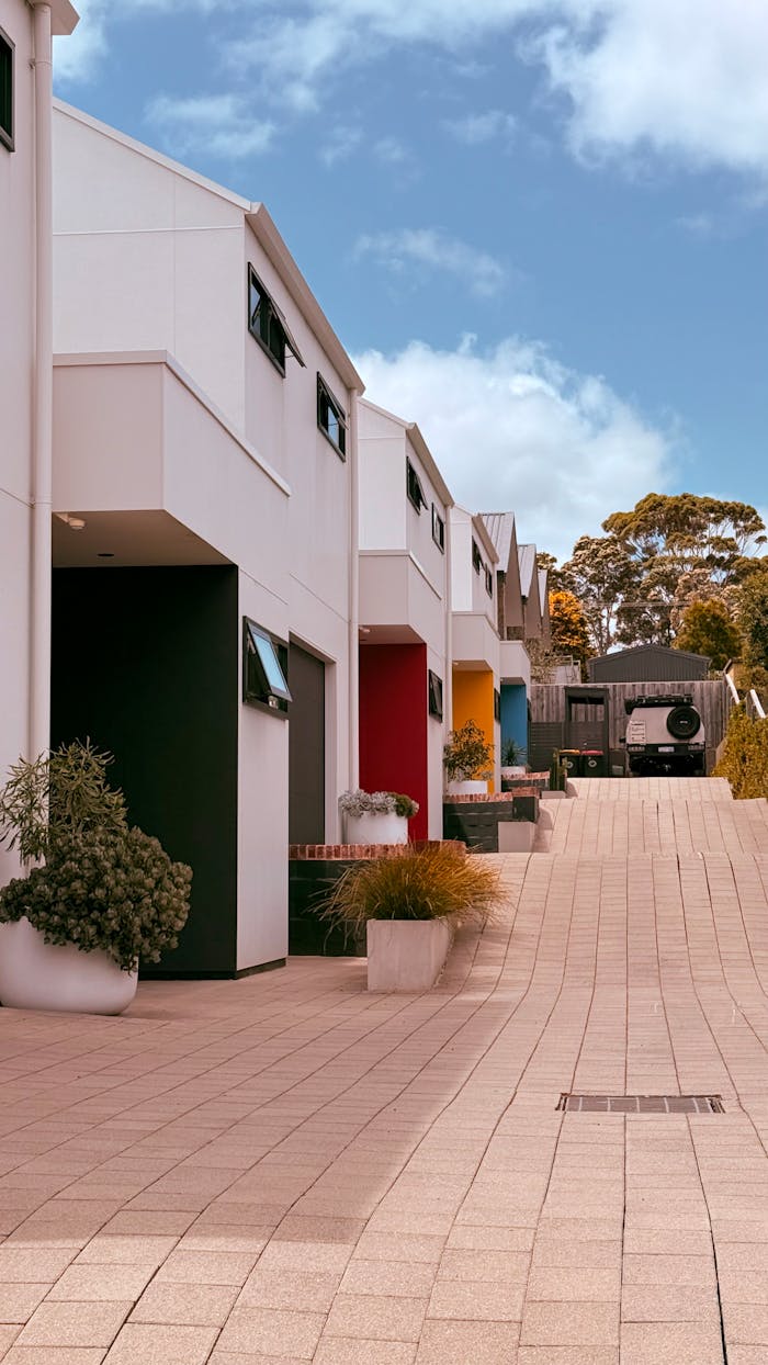services-01 A vibrant row of colorful townhouses under a bright blue sky, symbolizing modern urban living.