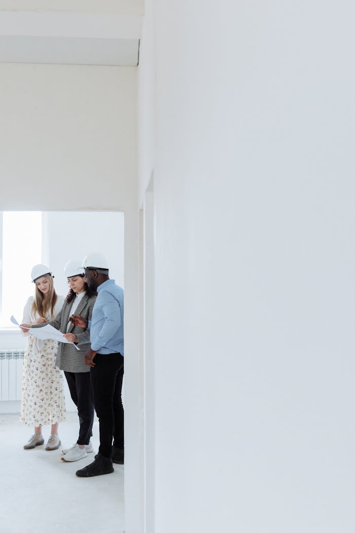 gallery-1 Team of architects discussing blueprints inside a newly built house.